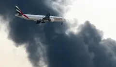 Một máy bay gần Sân bay Quốc tế Dubai bay trên nền khói do drone gây ra