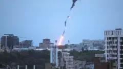 An explosion of a drone is seen in the sky over the city