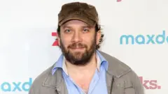 写真ひげを育てて茶色の帽子をかぶったクリスティアン・ウルメンがカメラを見つめている