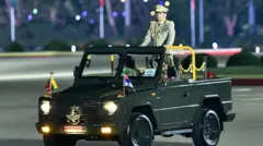 多数の勲章がついた軍服に、三つのメダルをかけたミンアウンフライン氏が、オープンカーの中で立っている