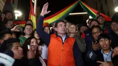 Rodrigo Paz com um colete vermelho, cercado de apoiadores