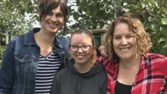 Ashley (centro) con sus nuevas madres.