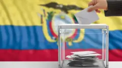 mão coloca cédula em urna de votação