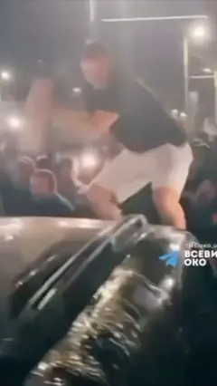 Мужчина стоит на крыше автомобиля