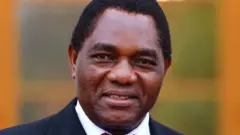 Perezida wa Zambia Hakainde Hichilema agaragara yambaye ikositimu n'ishati y'umweru. Ifoto yo mu bubiko. 