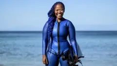 زانديل ندلوفو ببدلة الغوص على الشاطئ.