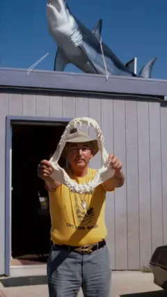 O pescador Frank Mundus mostra a mandíbula do tubarão capturado por ele