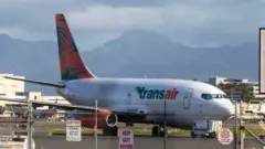 A Transair 737 cargo plane on the runway in Hawaii