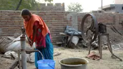 ਪਾਣੀ ਭਰਦੀ ਹੋਈ ਔਰਤ