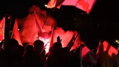 هزاران معترض با در دست داشتن پرچم و فشفشه سه‌شنبه شب در مقابل دفتر مرکزی حزب سوسیالیست در مادرید تجمع کردند