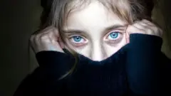 Una mujer se cubre el rostro