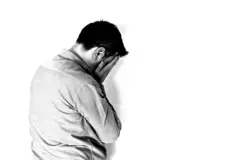 مشهد تمثيلي لرجل يضع يده على وجهه تعبيرا عن مشاعر القلق أو التوتر أو الحزن