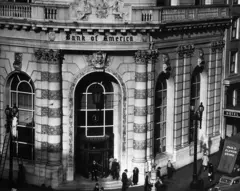 Entrada imponente do banco, com pessoas na rua