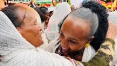 ሁለት ሴቶች ተቃቅፈው ሲሳሳሙ