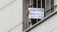 29일 서울 송파구 동부구치소에서 한 수용자가 자필로 '살려주세요'라고 쓴 문구를 취재진에게 보여주고 있다