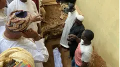 Oku Baba Suwe ti wọn tẹ sinu saare pẹlu asọ funfun ni awọn Alfa duro ti