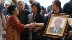 Istri almarhum Zetro Leonardo Purba Priskila Serapinta (kanan) mendapat ucapan duka cita dari kerabat saat acara prosesi pemakaman suaminya di TPU Sari Mulya, Setu, Tangerang Selatan, Banten, Kamis (11/9/2025).