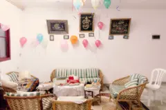 Sala com balões de festa, sofás e comida em mesas