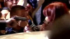 Arma a centímetros de Cristina Kirchner, que aparentemente sai de um carro no meio da multidão