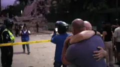 Dos hombres se abrazan frente a los escombros de un edificio que se derrumbó en el terremoto de 7,1 grados que azotó a Caracas el 24 de junio.