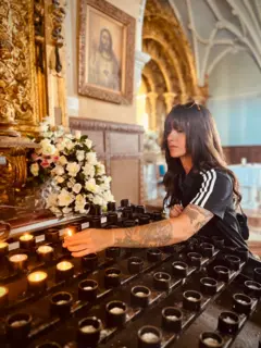 Anaí Meléndez acende uma vela em uma igreja