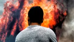 Firefighters and volunteers try to extinguish flames during a wildfire at the village of Kineta, near Athens, on 24 July 2018