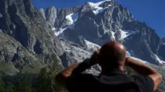 Hombre mirando las montañas en segundo plano.