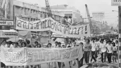 Youthful anti-government students march toward Bangkok's Thammasart University August 7. The demonstration is similar to that which brought down the military government of Field Marshall Thanom Kittikachorn in October 1973. They are carrying banners with slogans reading "You must return my people to me," referring to arrested students.