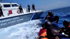 A migrant boat next to a Greek Coastguard boat