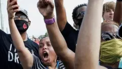 People shout and hold their phones during protests over George Floyd's death