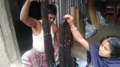 স্বামীর সঙ্গে মিলে পরচুলার কাজ করছেন পুতুল বেরা।