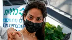 కరోనావైరస్ వ్యాక్సీన్ వేయించుకుంటున్న ఇజ్రాయెల్ మహిళ