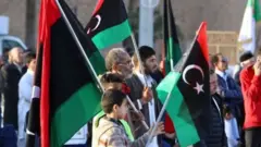 مواطنون يحملون علم ليبيا