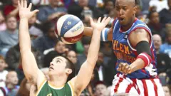 Harlem Globetrotter Shane 'Scooter' Christensen evades the reach of Washington General Caleb Kimbrough as he dribbles downcourt