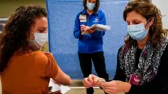 Healthcare workers take part in a rehearsal for the administration of the Pfizer coronavirus vaccine