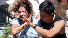 Mulher chorando, consolada por um homem em Manizales, na Colômbia.
