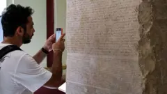 Pengunjung mengambil gambar salinan "Dekrit Canopus" yang ditemukan pada tahun 1881 oleh Gaston Maspero di situs Kom el-Hisn di delta Nil Mesir