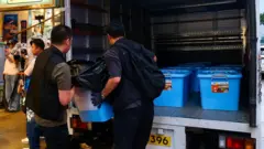 警员将检获物品搬上一辆警车。