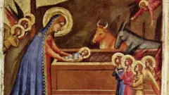 Pintura medieval mostra Maria colocando o bebê Jesus na manjedoura, com anjos rezando e um boi e um burro ao fundo. Obra7games android gamBernardo Daddi, por volta7games android gam1325