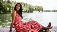 Woman with smartphone on dock at lake