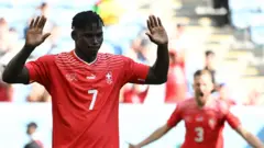 卡塔爾沃克拉南部體育場FIFA世界盃G組瑞士對喀麥隆賽事,瑞士球員布雷爾·恩博洛身穿印有7號的紅色球衣,在進球後舉起雙臂,表情懊惱。(24/11/2022)