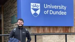  Dener Silva Mirandacupom betano maio 2024frente ao logotipo da Universidadecupom betano maio 2024Dundee, na Escócia, onde ele estudou pelo programa Ciência Sem Fronteiras