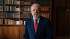 Lula olhando para a câmera. Atrás há uma biblioteca