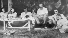 En una fotografía de álbum tomada en una fecha no revelada durante la década de 1970, se muestra a Wolfgang Gerhard, presuntamente Josef Mengele, sentado con amigos (en el centro, al borde de la mesa).