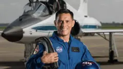 Frank Rubio con un traje azul de la NASA.