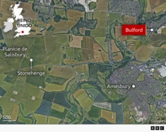 Mapa mostrando o contorno do Reino Unido no canto superior esquerdo em branco. A principal imagem maior é uma imagem de satélite da planície de Salisbury com Stonehenge e Bulford marcados no mapa. Bulford é destacado em vermelho com escrita branca.