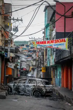 Carro queimado bloqueia passagem na favela