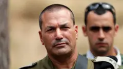 رئيس الأركان الإسرائيلي يبدو في زيه العسكري وخلفه يبدو أحد مرافقيه وصورته غير واضحة