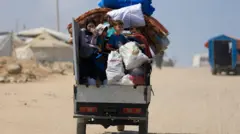 Palestinos desplazados que huyen del norte de Gaza viajan con sus pertenencias mientras se dirigen al sur, en medio de una operación militar israelí, en la ciudad de Gaza, el 21 de agosto.