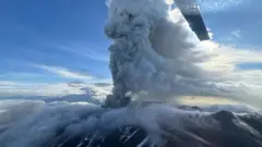 Veliki oblak pepela uzdiže se iznad vulkana. Fotografija je, izgleda, snimljena iz helikoptera jer su lopatice rotora u prvom planu.
